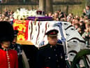 Soldiers accompany a gun carriage holding the coffin bearing the Queen Mother April 5, 2002.