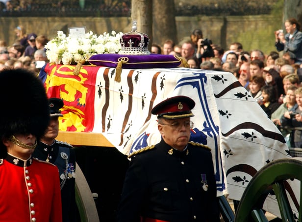 <p>Soldiers accompany a gun carriage holding the coffin bearing the Queen Mother April 5, 2002.</p>