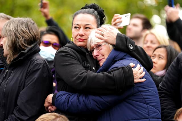Members of the crowd on The Mall listen during the State Funeral of Queen Elizabeth II at Westminster Abbey on September 19, 2022 in London, England. Elizabeth Alexandra Mary Windsor was born in Bruton Street, Mayfair