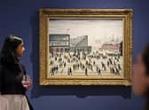 A visitor walks past "Going to the Match" by English artist LS Lowry from 1928, on display at a Christie's exhibition in Dubai on September 15, 2022