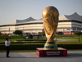 A man takes a picture of a FIFA World Cup trophy replica in front of the Al-Bayt Stadium in al-Khor on November 10, 2022, ahead of the Qatar 2022 FIFA World Cup football tournament. (Photo by Kirill KUDRYAVTSEV / AFP) (Photo by KIRILL KUDRYAVTSEV/AFP via Getty Images)