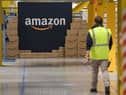 A US giant Amazon employee passes by its logo on the opening day of the new distribution center in Augny, eastern France, on September 23, 2021. (Photo by SEBASTIEN BOZON/AFP via Getty Images)