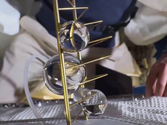 Liat Segal & Dr. Yasmine Meroz's artwork being unveiled on the ISS where microgravity allows the water to stick to the metal frame in large globules