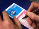  A punter fills out a National Lottery ticket.
