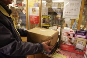 Customers weigh packages at the post office.