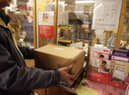 Customers weigh packages at the post office.