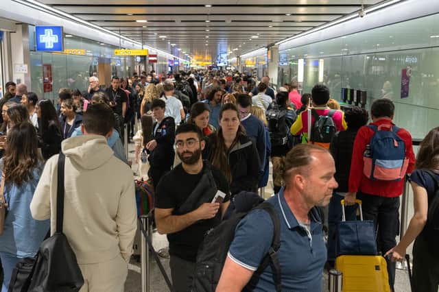 Travellers wait in a long queue to pass through the security check at Heathrow.
