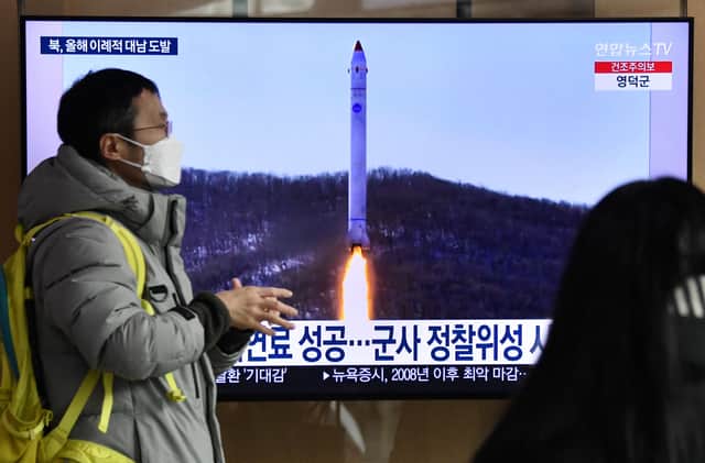 A man walks past a television screen showing a news broadcast with file footage of a North Korean missile test, at a railway station in Seoul on December 31, 2022 after North Korea fired three short-range ballistic missiles according to South Korea's military. 