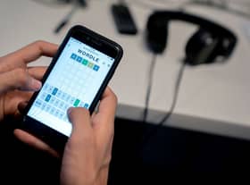 This photo illustration shows a person playing online word game “Wordle” on a mobile phone in Washington, DC on January 11, 2022 (Photo by STEFANI REYNOLDS/AFP via Getty Images)