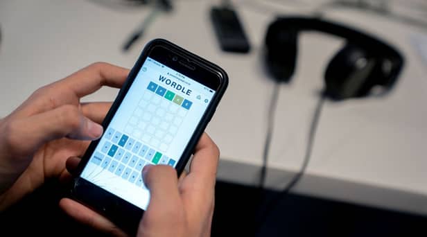 This photo illustration shows a person playing online word game “Wordle” on a mobile phone in Washington, DC on January 11, 2022 (Photo by STEFANI REYNOLDS/AFP via Getty Images)