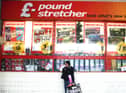 A woman waits outside a branch of Poundstretcher near Lewisham high street.