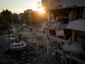 Men walk down a street amid rubble from destroyed buildings on February 20, 2023 in Hatay, Turkey