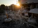 Men walk down a street amid rubble from destroyed buildings on February 20, 2023 in Hatay, Turkey