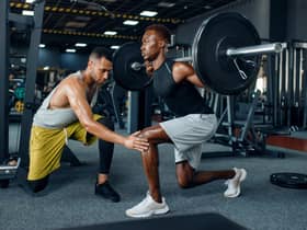 Man with his trainer in gym (Adobe)
