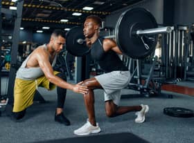 Man with his trainer in gym (Adobe)