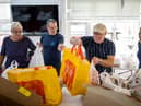 Volunteers sort food into food parcels at a community charity.  