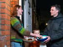 Adam Walters with his son delivering potatoes to one of his neighbours in Lloyds Park, Walthamstow.  