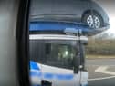 Police officers overtaking a heavily-laden car transporter were shocked to discover the driver was using just one elbow to control the huge vehicle as he travelled along a busy motorway. 