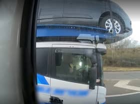 Police officers overtaking a heavily-laden car transporter were shocked to discover the driver was using just one elbow to control the huge vehicle as he travelled along a busy motorway. 