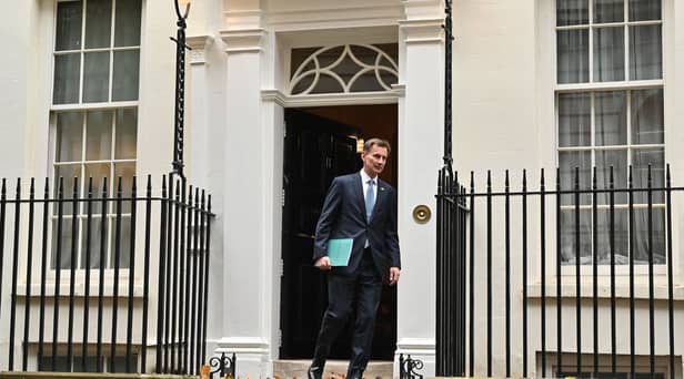 Britain's Chancellor of the Exchequer Jeremy Hunt walks out of Number 11 Downing Street 