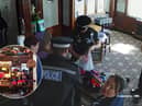CCTV footage shows police storming a couple's Essex pub and seizing their golliwog dolls, saying the toys were a suspected hate crime (Photos: SWNS)