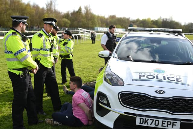 An animal rights protester is apprehended by police officers ahead of the Grand National. 