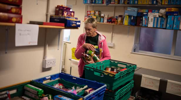 A worker at the Coventry Foodbank centre in Queens Road Baptist Church collates donated food items into parcels that will be provided to people arriving with a foodbank voucher.