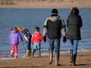 Family playing at the seaside in winter, Instow, Devon, UK. (Photo by: Education Images/Universal Images Group via Getty Images)