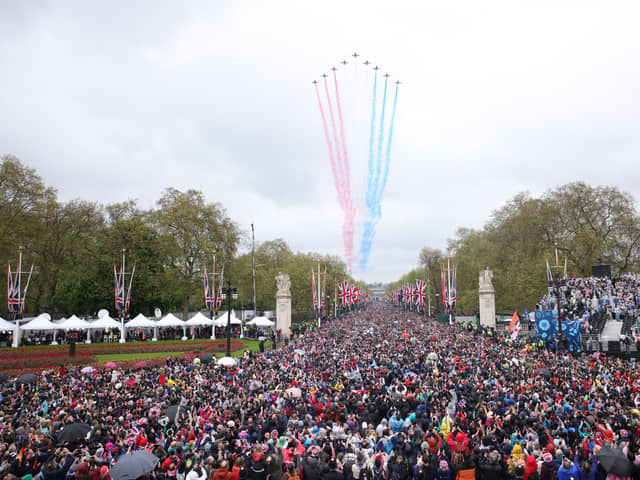 Crowds made their way down the Mall and towards Buckingham Palace, to greet to the new King and Queen at the balcony of Buckingham Palace. Shortly after the royal arrival on the balcony, a traditional Red Arrow flyover - which had been scaled back due to weather - brightened the rainy skies over London. (Credit: Getty Images)