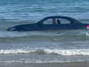 A convertable BMW was washed out to see after parking on a beach in Cornwall
