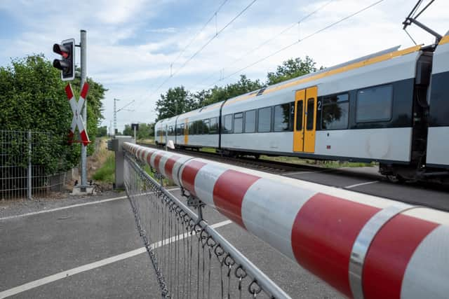 A CCTV clip has shown the heart-stopping moment a woman has a near miss with a train on a level crossing