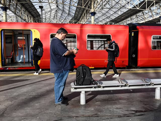 Commuters walk past a train stopped at a platform in Waterloo Station in London, during a national strike day, on February 1, 2023.