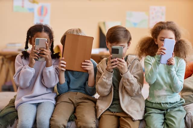 Group of young children holding smartphones. Photo: Seventyfour - stock.adobe.com