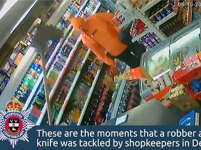 Moment brave shopkeeper fends off armed robber with a mop.
