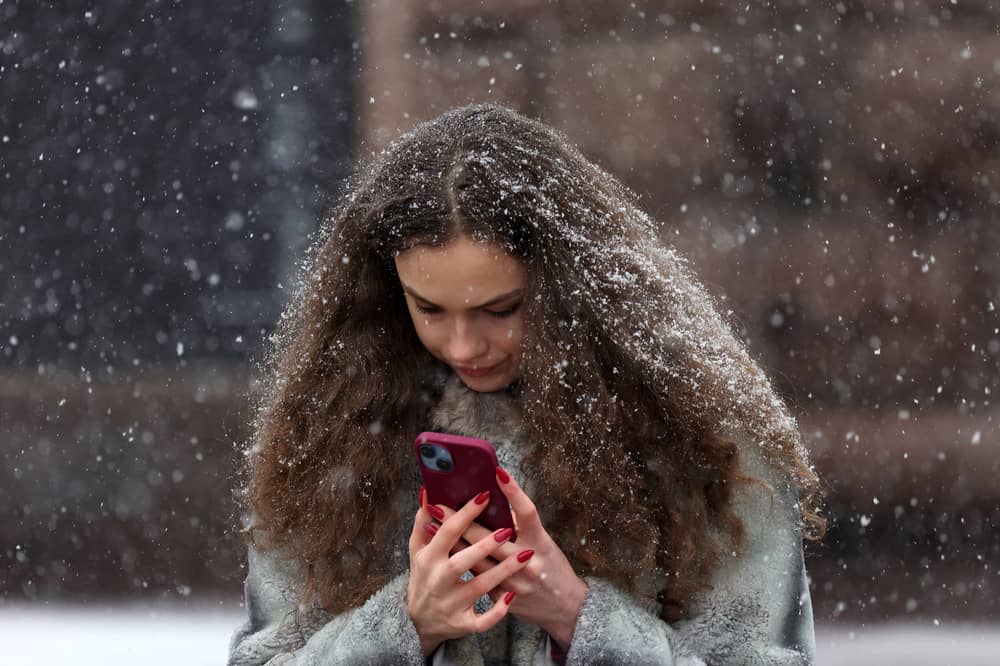 Woman on a smartphone in a snowstorm. Photo: ANATOLII STEPANOV/AFP via Getty Images