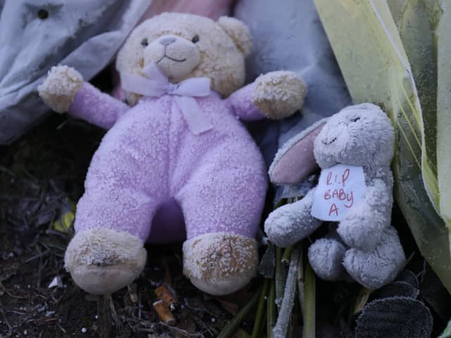 Flowers and stuffed toys are left as tributes to 'Baby A'.