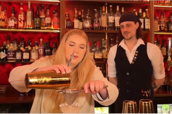 A reporter creates the bar's famous margarita with the help of a bartender