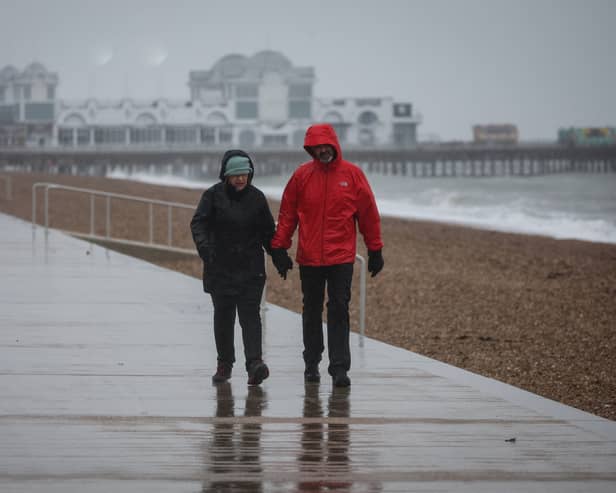 A couple walk in heavy rain on the South Parade Pier, in Portsmouth.
