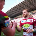 Adam Keighran celebrates a Wigan Warriors win with teammate Harvie Hill