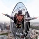 Adam Lockwood, from Wigan, parachutes off the Link building in Paris.