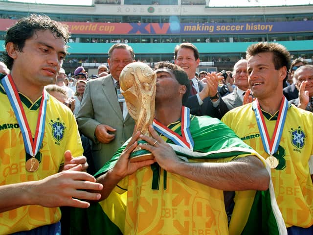 Brazilian forward Romario kisses the FIFA World Cup trophy 1994 as his teammates Branco (left) and Dunga look on. Brazil defeated Italy in the final on penalties when the tournament was last held in the United States