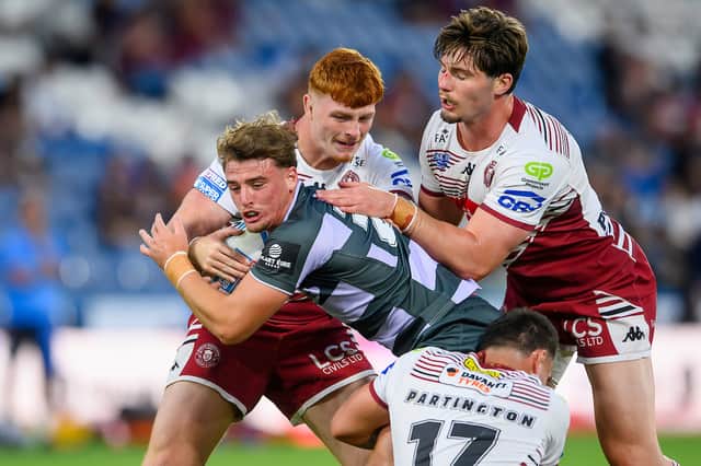 Shea O'Connor (centre) in action for Wigan Warriors against Huddersfield Giants