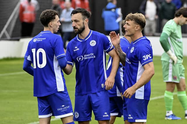 Chris Sze (left), Morgan Fox (centre) and Max Power (right) embrace in Wigan Athletic's 3-0 pre-season win over AFC Fylde
