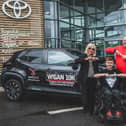 Jack Johnson does the "Joining Jack salute" as he receives the keys to the Wigan 10k lead car from Steve Mather, centre principal, and Dorothy Moon, managing director, at HW Moon Toyota. Picture: Michelle Charnock Photographer