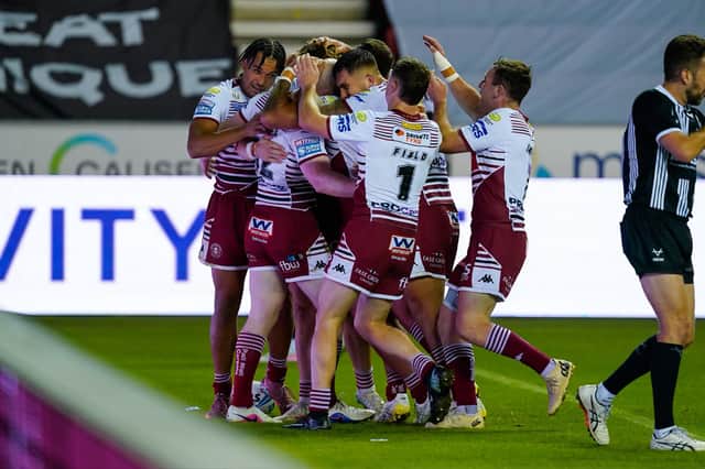 Wigan Warriors players celebrate a try against Catalans Dragons