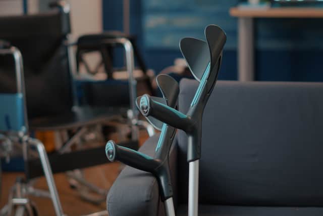 Crutches on empty couch in living room to give mobility support to people with chronic disability or injury. Walking sticks helping with transportation and physical accessibility. Walk crutch