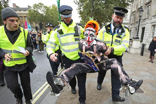 Police holding an Extinction Rebellion protestor