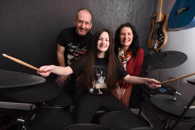 Young drummer Jasmine Rogers, 13, from Ashton-in-Makerfield, has passed her grades with distinction, pictured with dad Kevin and mum Lynne (right)