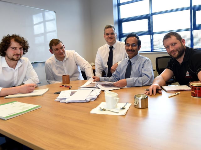 Eddie Webb, centre, with colleagues during a meeting in the board room at Sanderson Watts Associates.