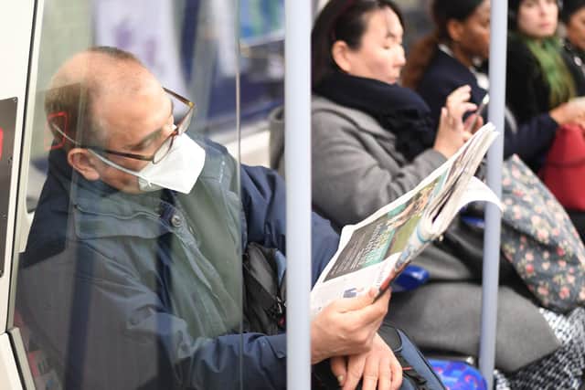 A man on an underground train wearing a protective mask